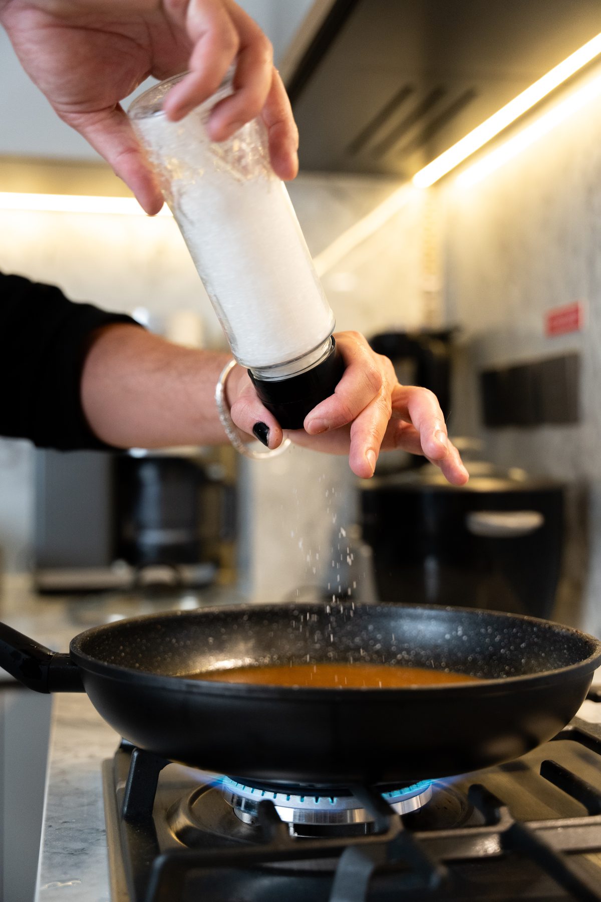 Chef finishing a dish over heat